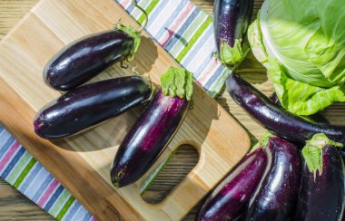 bir kara tahta üzerinde taze mor patlıcan demet