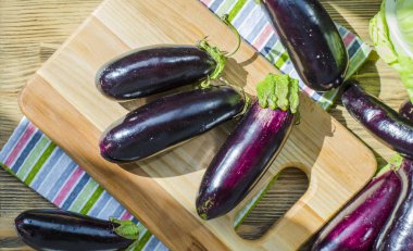 bir kara tahta üzerinde taze mor patlıcan demet