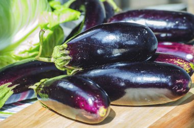 bir kara tahta üzerinde taze mor patlıcan demet