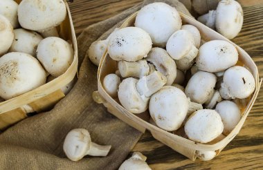 Ahşap masa üzerinde bir sepet içinde taze champignon mantar