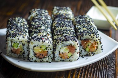 Suşi orkinos karanlık bir arka plan üzerinde siyah susam ile