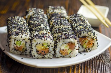 Suşi orkinos karanlık bir arka plan üzerinde siyah susam ile