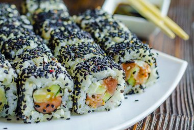 Suşi orkinos karanlık bir arka plan üzerinde siyah susam ile