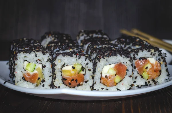 Suşi orkinos karanlık bir arka plan üzerinde siyah susam ile