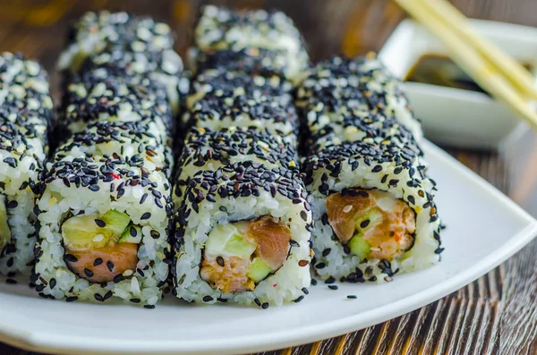 sushi with tuna in black sesame on a dark background