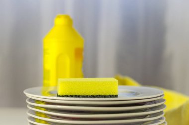 Bulaşık yıkama sıvısı şişesi ve mutfak eşyaları yığını