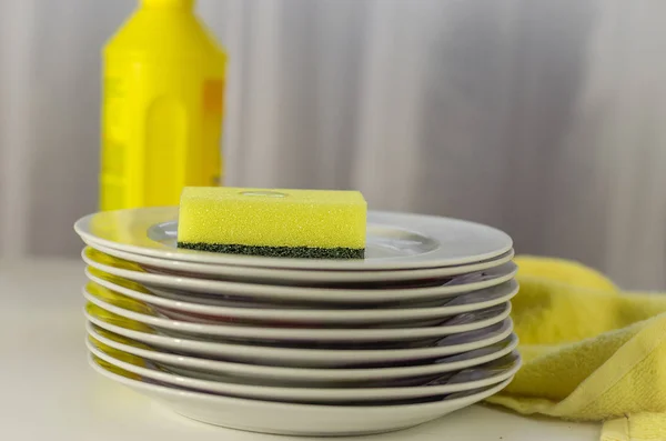 Bottle of dishwashing liquid and stack of utensils