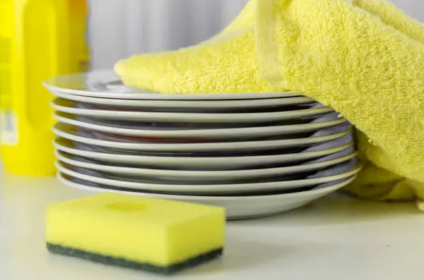 Bottle of dishwashing liquid and stack of utensils — Stock Photo, Image