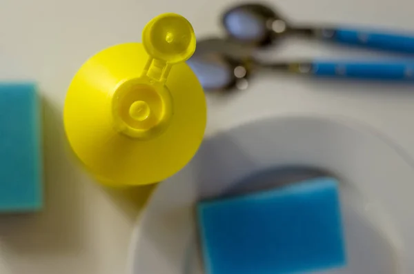 Bulaşık yıkama sıvısı şişesi ve mutfak eşyaları yığını