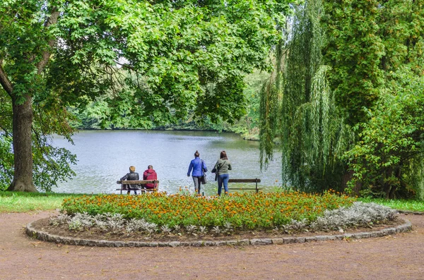 Pessoas no lago no banco — Fotografia de Stock