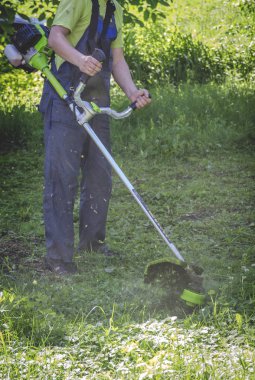 İşçi çimleri bir düzeltici ile keser.