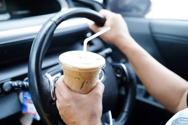 Asian woman driver hold drink in car, dangerous and risk an accident.