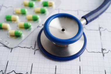 Elektrokardiyogramda stetoskop. Kapsül ilacı, kalp dalgası, kalp krizi, kardiyogram raporu..