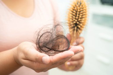 Asian woman have problem with long hair loss attach in her hand.
