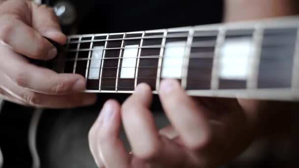 Музикант використовує техніку постукування, щоб грати на електрогітарі, граючи на електричних музичних інструментах, граючи голосно на гітарі, рок-гітарі — стокове відео
