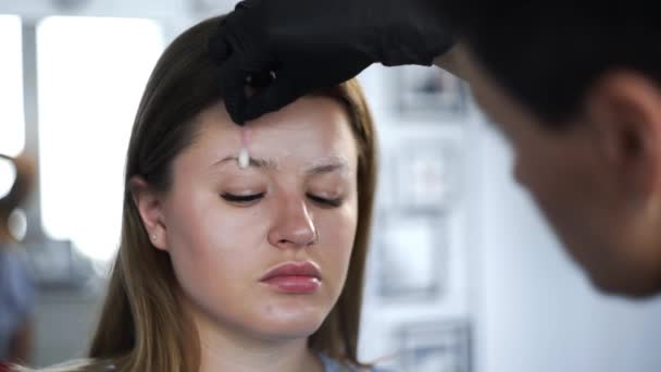 Maquillaje artista hace tinción de cejas con tintes naturales, tonificación con henna, procedimientos cosméticos en el salón de belleza — Vídeo de stock