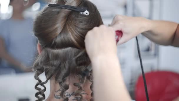 El estilista hace el peinado afro rizado para la mujer por el pelo rizado caliente, proceso de hacer el peinado, peinados en el salón de belleza — Vídeo de stock