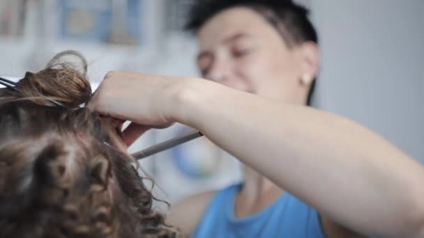 Stylist faz encaracolado afro penteado para a mulher por cabelo de ondulação quente, processo de fazer penteado, penteados no salão de beleza — Vídeo de Stock