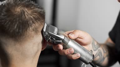 Tattoed berber kuaför dükkanında müşteri için saç kesimi hairclipper kullanarak yapar, saç kesimi ve tıraş Kuaför, berber dükkanı ve tıraş salon mans