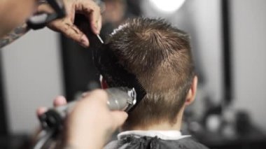 Tattoed berber kuaför dükkanında müşteri için saç kesimi hairclipper kullanarak yapar, saç kesimi ve tıraş Kuaför, berber dükkanı ve tıraş salon mans
