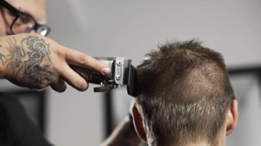 Tattoed berber kuaför dükkanında müşteri için saç kesimi hairclipper kullanarak yapar, saç kesimi ve tıraş Kuaför, berber dükkanı ve tıraş salon mans