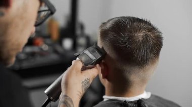 Tattoed berber kuaför dükkanında müşteri için saç kesimi hairclipper kullanarak yapar, saç kesimi ve tıraş Kuaför, berber dükkanı ve tıraş salon mans