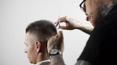 Tattoed berber kuaför dükkanında müşteri için saç kesimi makas ve tarak kullanarak yapar, saç kesimi ve tıraş Kuaför, berber dükkanı ve tıraş salon mans