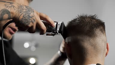 Tattoed berber kuaför dükkanında müşteri için saç kesimi hairclipper kullanarak yapar, saç kesimi ve tıraş Kuaför, berber dükkanı ve tıraş salon mans