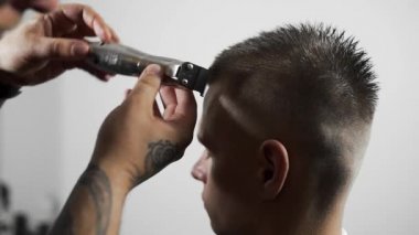 Tattoed berber kuaför dükkanında müşteri için saç kesimi hairclipper kullanarak yapar, saç kesimi ve tıraş Kuaför, berber dükkanı ve tıraş salon mans