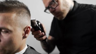 Tattoed berber kuaför dükkanında müşteri için saç kesimi hairclipper kullanarak yapar, saç kesimi ve tıraş Kuaför, berber dükkanı ve tıraş salon mans