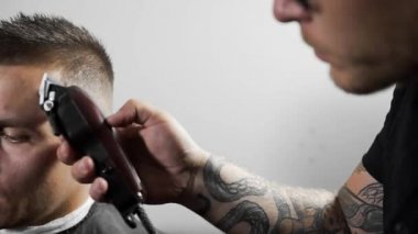 Tattoed berber kuaför dükkanında müşteri için saç kesimi hairclipper kullanarak yapar, saç kesimi ve Kuaför, Kuaför Salonu, tıraş mans