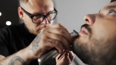 Kuaför dükkanında düzeltici kullanarak müşteriler sakal Tattoed Kuaför makası mans saç kesimi ve tıraş Kuaför, berber dükkanı ve tıraş salon