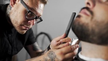 Kuaför dükkanında düzeltici kullanarak müşteriler sakal Tattoed Kuaför makası mans saç kesimi ve tıraş Kuaför, berber dükkanı ve tıraş salon