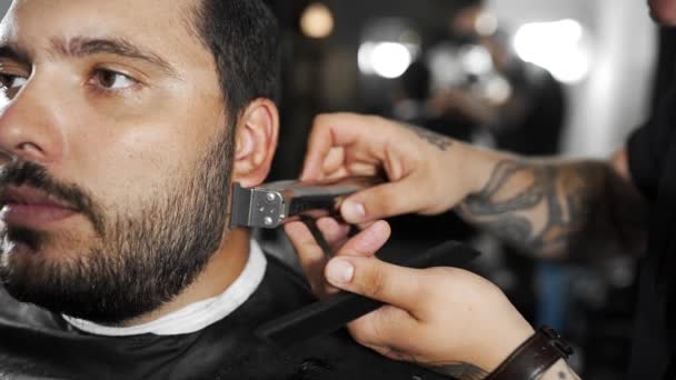 Tatueras frisör sax kunderna skägget med trimmern på frisersalong, mans frisyr och rakning på frisör, frisörsalong och rakning salong — Stockvideo