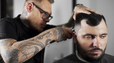 Tattoed berber kuaför dükkanında müşteri için saç kesimi hairclipper kullanarak yapar, saç kesimi ve tıraş Kuaför, berber dükkanı ve tıraş salon mans