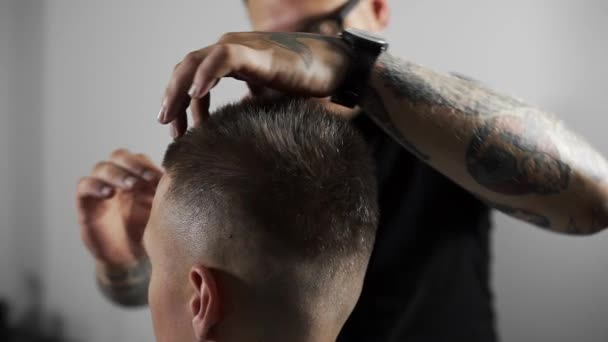 Barbiere tatuato rende lo styling dei capelli con gel per capelli per il cliente dopo il taglio di capelli presso il negozio di barbiere, taglio di capelli mans e rasatura presso il parrucchiere, barbiere e salone da barba — Video Stock