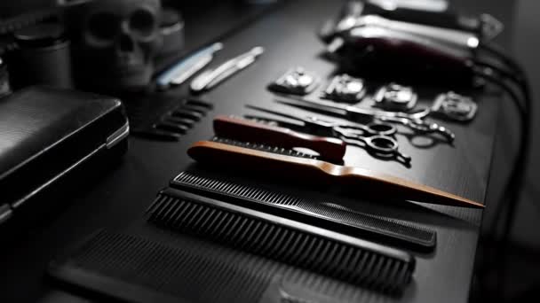 Stylish equipment table with scissors and trimmers and dark scull at the barber shop, making of haircuts, straight razor on the table, shaving salon — Stock Video