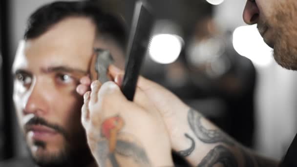 Tätowierte Friseur macht Haarschnitt für Kunden im Friseursalon mit Haarschneidemaschine, Herrenfriseur und Rasur beim Friseur, Friseur und Rasiersalon — Stockvideo