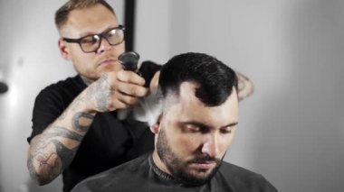 Kuaför çırpma aletleri uzak müşteriler omuz üzerinden tüyler fırça ile nın yaşadığı, Kuaför Salonu, müşteride mans için saç kesimi tattoed Kuaför saç kesimi yapar ve kuaförde tıraş, berber dükkanı ve tıraş