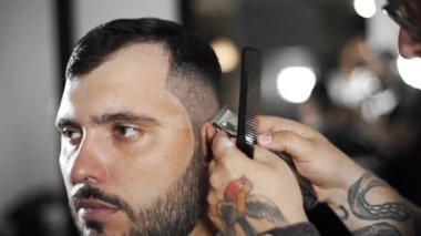 Tattoed berber kuaför dükkanında müşteri için saç kesimi hairclipper kullanarak yapar, saç kesimi ve tıraş Kuaför, berber dükkanı ve tıraş salon mans