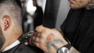 Tattoed berber kuaför dükkanında müşteri için saç kesimi hairclipper kullanarak yapar, saç kesimi ve tıraş Kuaför, berber dükkanı ve tıraş salon mans