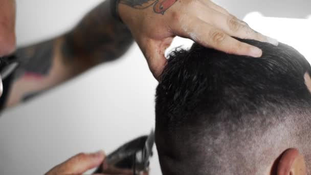 Peluquero tatuado hace corte de pelo para el cliente en la peluquería mediante el uso de peluquero, corte de pelo mans y afeitarse en la peluquería, peluquería y salón de afeitar — Vídeos de Stock