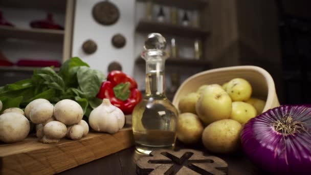 Verduras coloridas están en la mesa de la cocina, ingredientes para cocinar en casa, papas, champiñones, pimienta y cebolla en la cocina, dieta saludable comida vegetariana — Vídeo de stock
