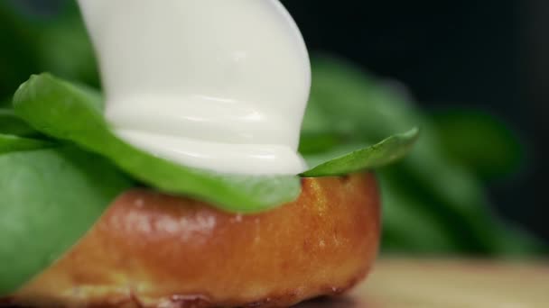 Chef tejszínes mártással hozzáadja a burger, zöldségek és zöldek, zsemlét és hamburgerek, hogy a Burger főzés a gyorsétterem — Stock videók