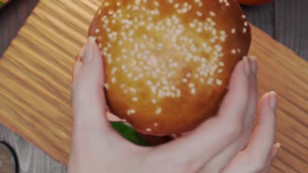 Le cuisinier rassemble un hamburger, fabrication d'un hamburger, saucisses et petits pains, restauration rapide, recettes de hamburgers — Video