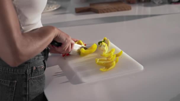 Femme sexy coupe le poivron jaune avec le couteau pointu sur la planche, femme cuisine plat de légumes à la cuisine, faire la pâte, boulangerie et pain — Video