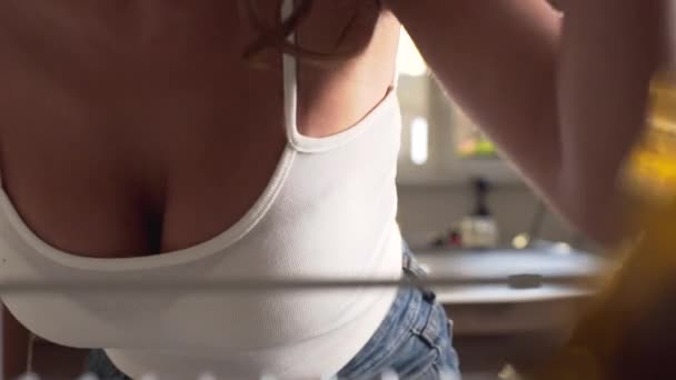 性感的女人与大布雷斯特打开冰箱和搜索食物 从冰箱像女人打开它 大花圈性感家庭主妇在家庭厨房 — 图库视频影像