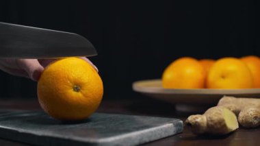 Turuncu rock kurulu, dilim taze turuncu, meyve ve vitaminler, keskin bıçak tarafından vejetaryen diyet, kesilerek taze meyve suyu yapıyor