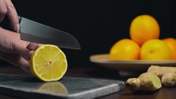 Cytryna jest podzielona przez ostrym nożem na pokładzie rock, plasterki świeżej pomarańczy, owoców i witamin, dieta wegetariańska, Dokonywanie świeżego soku — Wideo stockowe