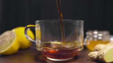 Sıcak siyah çay dökülür cam fincan, vitamini çay limon, zencefil ve ballı, iç hastalık karşı sıcak içecekler
